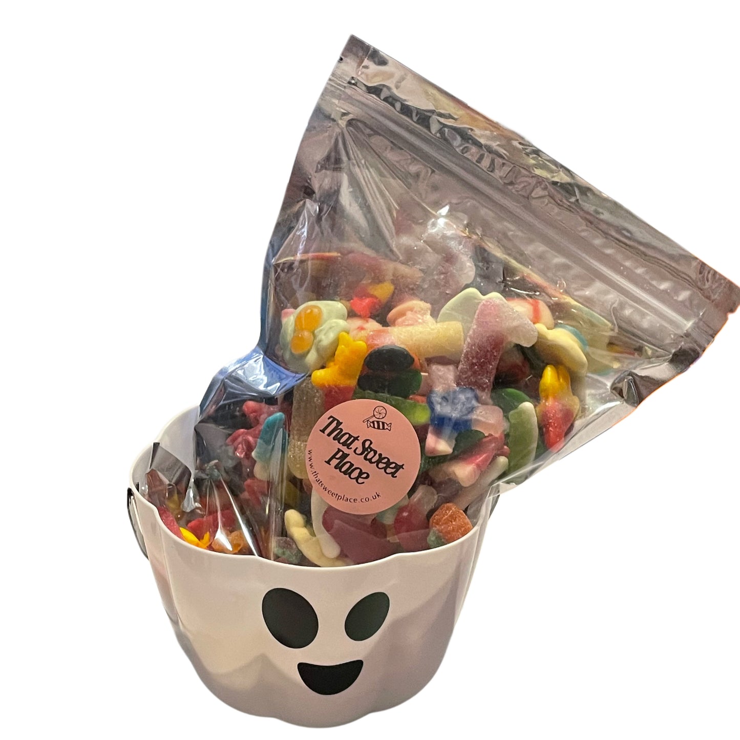 Bag of colorful gummy candies with a ghost-shaped container on a white background