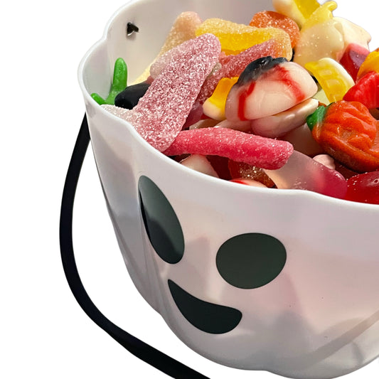 Ghost-shaped halloween loot bucket filled with colorful gummy candies on a white background